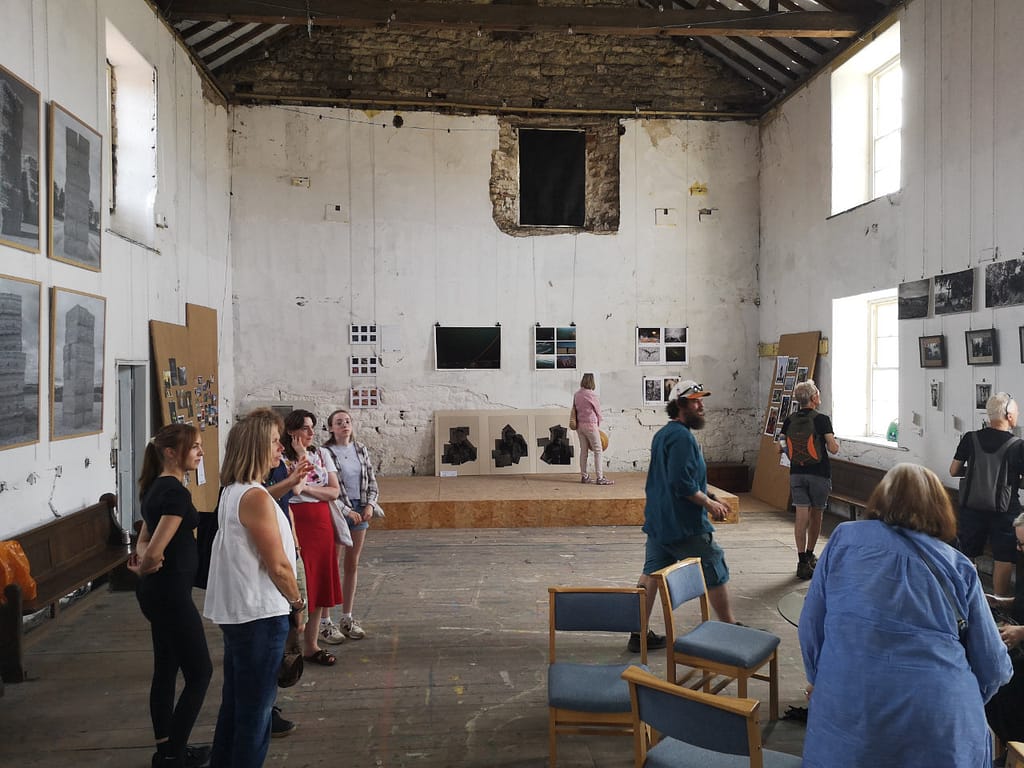 Groups of people chatting and looking at the photos hung in the Parish Project in Malton as part of the Ryedale Film and Photo Fest 2026.